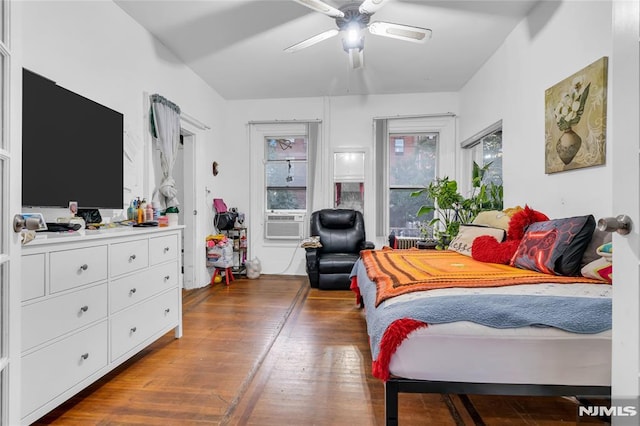 bedroom featuring ceiling fan, cooling unit, and wood-type flooring