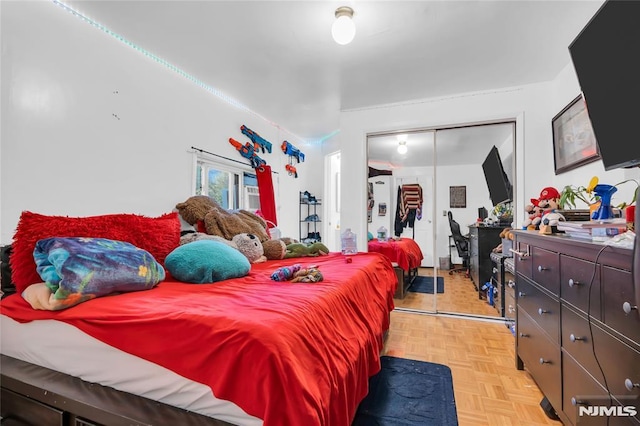 bedroom featuring a closet and light parquet flooring