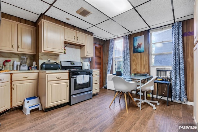 kitchen with a drop ceiling, gas stove, light wood-type flooring, and light brown cabinets