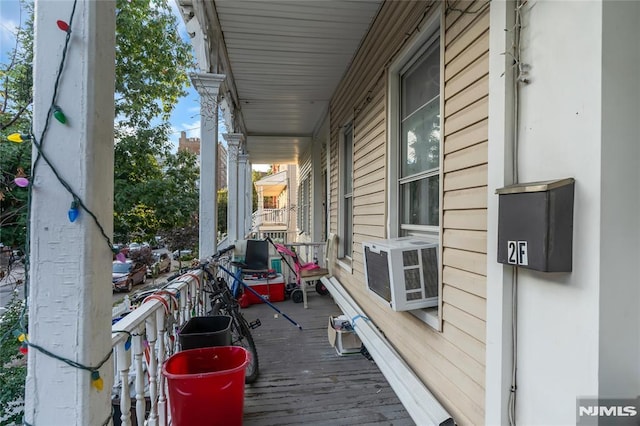 wooden terrace with cooling unit and covered porch