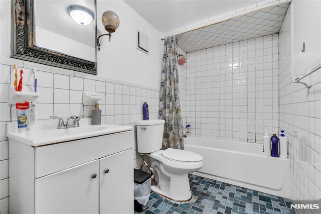 full bathroom featuring vanity, shower / bath combo, toilet, and tile walls