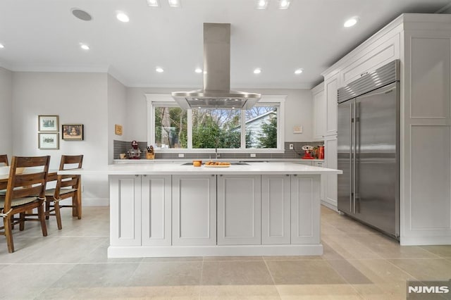 kitchen featuring white cabinetry, island range hood, a center island, and stainless steel built in refrigerator