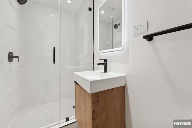 bathroom featuring vanity and a shower with door