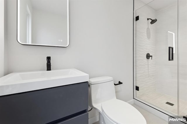 bathroom with toilet, a shower with door, and vanity