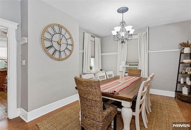 dining space with an inviting chandelier, cooling unit, and dark hardwood / wood-style flooring