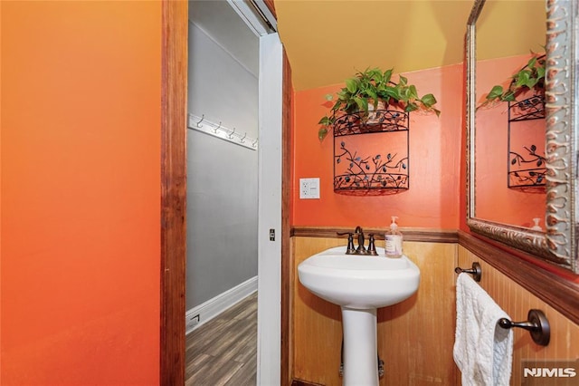 bathroom featuring wood-type flooring and wood walls