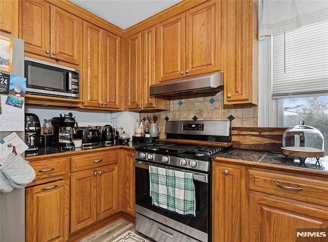 kitchen with stainless steel appliances and decorative backsplash