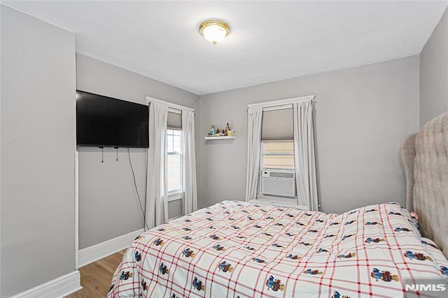 bedroom with light hardwood / wood-style floors and cooling unit