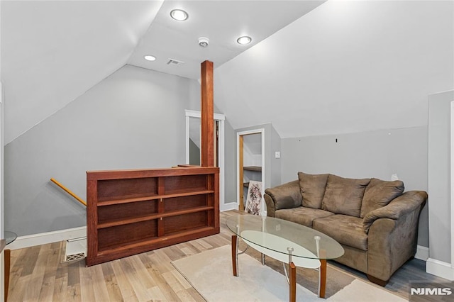 living room with light wood-type flooring and vaulted ceiling