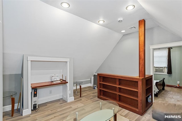 interior space featuring lofted ceiling, light hardwood / wood-style floors, and cooling unit