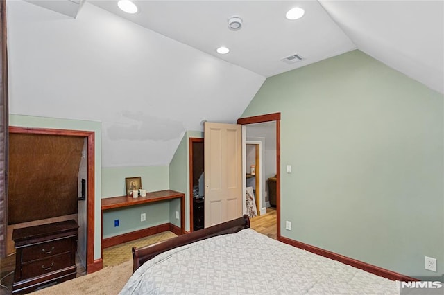 bedroom featuring lofted ceiling and light colored carpet