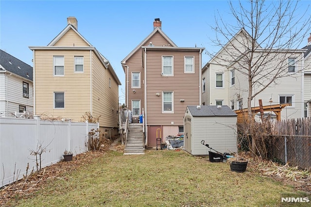 back of property featuring a yard and a storage shed