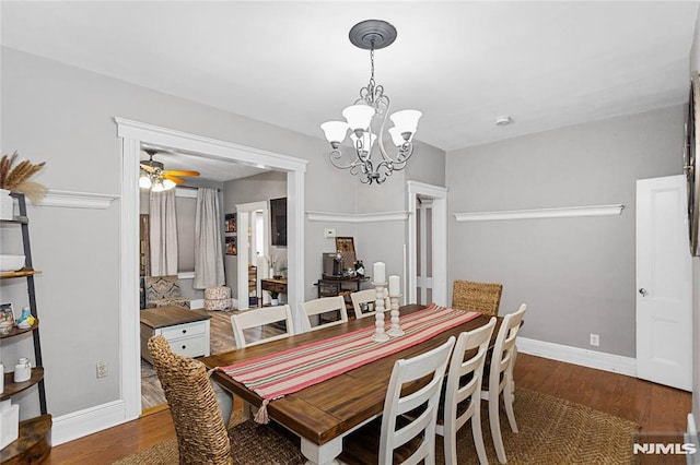 dining space featuring dark hardwood / wood-style flooring and ceiling fan with notable chandelier