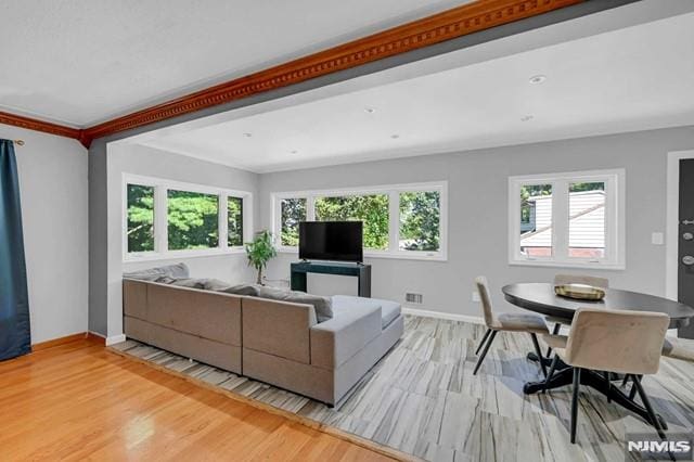 living room with light wood-type flooring and crown molding