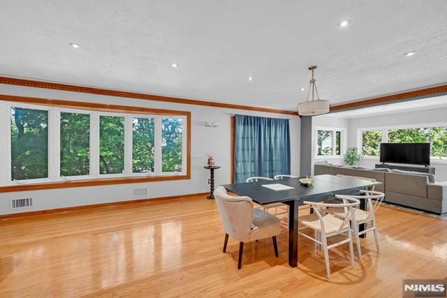 dining room featuring light hardwood / wood-style flooring and ornamental molding