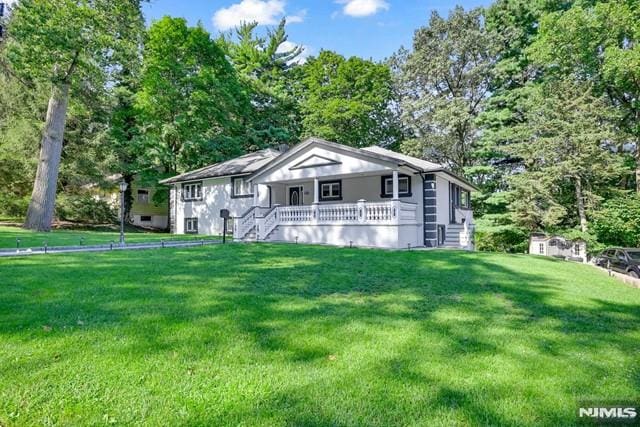 view of front of home featuring covered porch and a front lawn