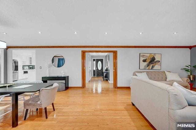 living room featuring light wood-type flooring and ornamental molding