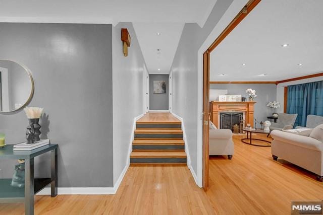 hallway featuring light wood-type flooring and crown molding