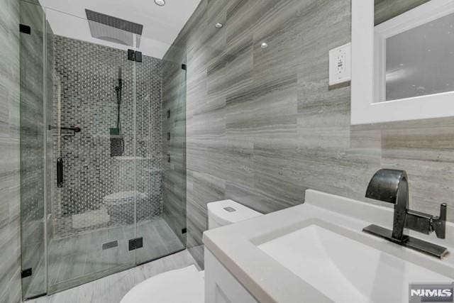 bathroom featuring vanity, an enclosed shower, and toilet