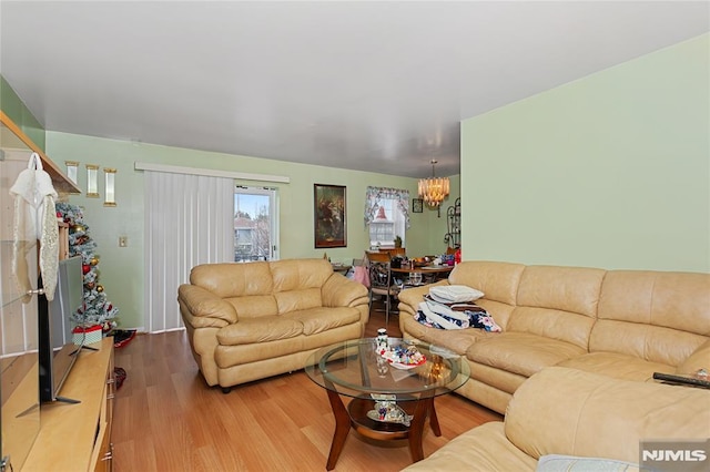 living room with hardwood / wood-style floors and a notable chandelier