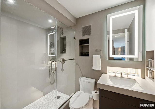 bathroom with a shower, vanity, and toilet