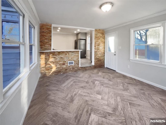 unfurnished living room featuring parquet flooring and crown molding