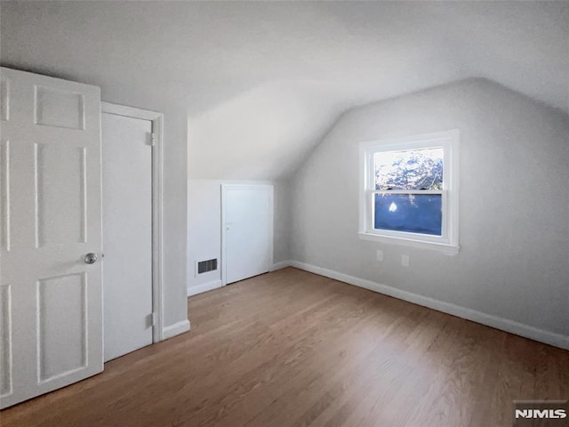 bonus room featuring wood-type flooring and vaulted ceiling