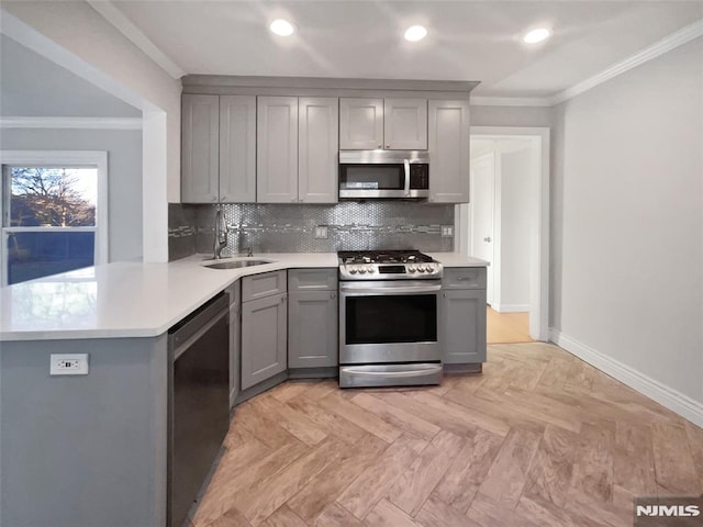 kitchen with sink, appliances with stainless steel finishes, gray cabinets, and kitchen peninsula