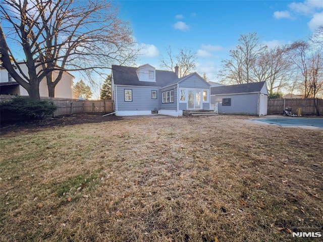 rear view of house featuring a covered pool, a yard, and a patio