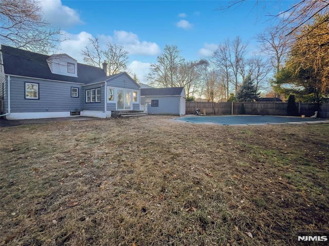 back of property with a yard and a patio