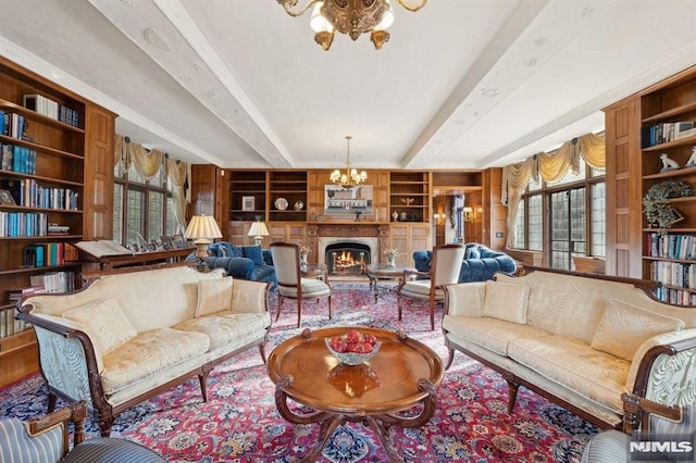 living room with built in shelves, a wealth of natural light, and a chandelier