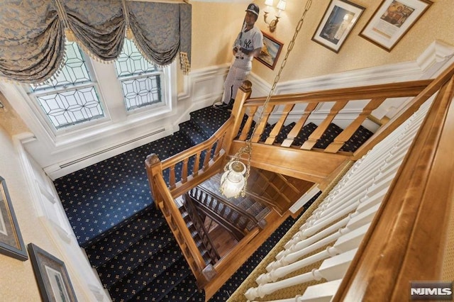 staircase featuring carpet floors and baseboard heating