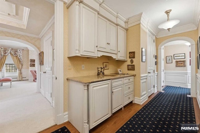 kitchen featuring dark wood-type flooring, sink, pendant lighting, and ornamental molding