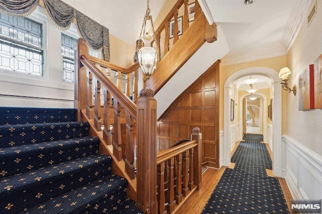 stairway featuring hardwood / wood-style floors and ornamental molding