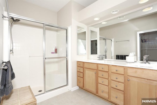 bathroom featuring tile patterned flooring, vanity, and walk in shower