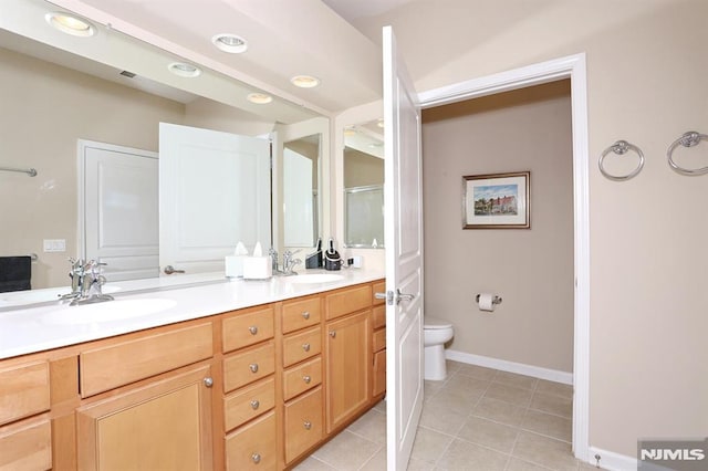 bathroom featuring tile patterned flooring, vanity, and toilet