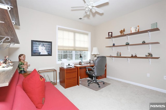 carpeted office space featuring ceiling fan