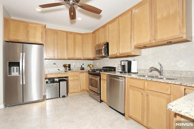 kitchen with sink, ceiling fan, light stone countertops, light brown cabinetry, and stainless steel appliances