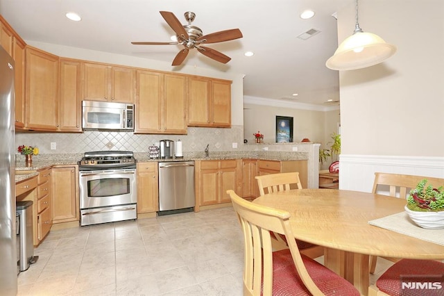 kitchen with light stone countertops, pendant lighting, stainless steel appliances, and light brown cabinetry