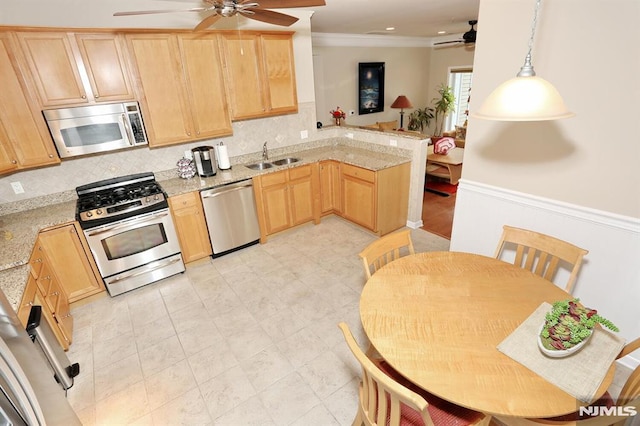 kitchen with light brown cabinetry, light stone countertops, hanging light fixtures, and appliances with stainless steel finishes