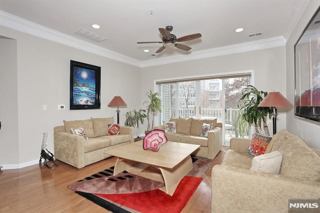 living room featuring hardwood / wood-style floors, ceiling fan, and crown molding