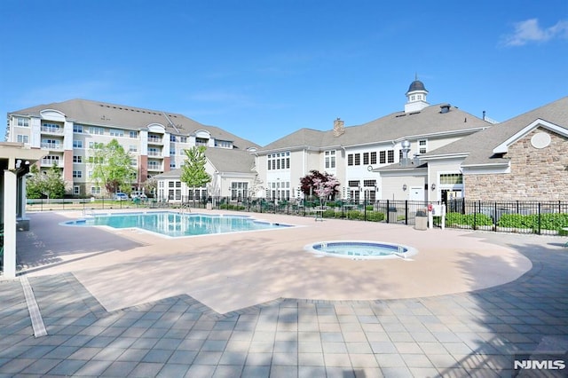 view of swimming pool with a hot tub