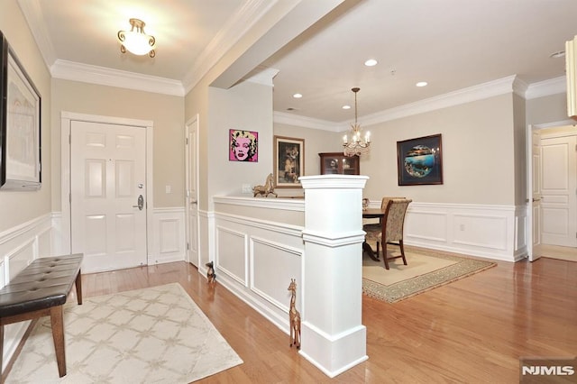 entryway featuring light hardwood / wood-style flooring, an inviting chandelier, and ornamental molding