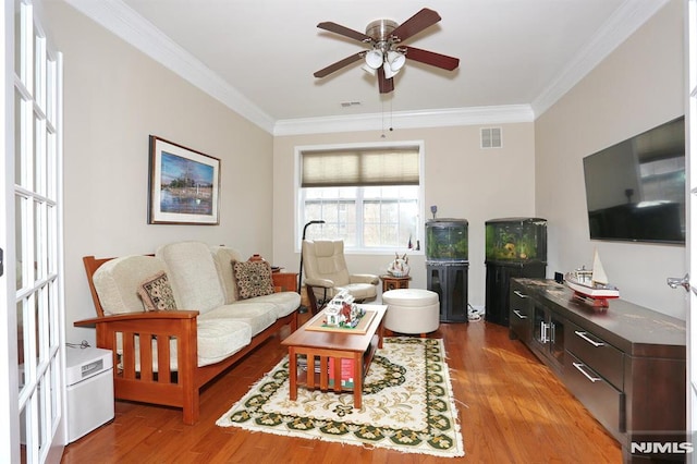 living room featuring crown molding, ceiling fan, and hardwood / wood-style flooring