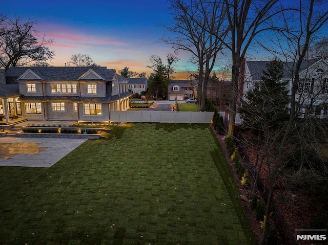 yard at dusk featuring a patio