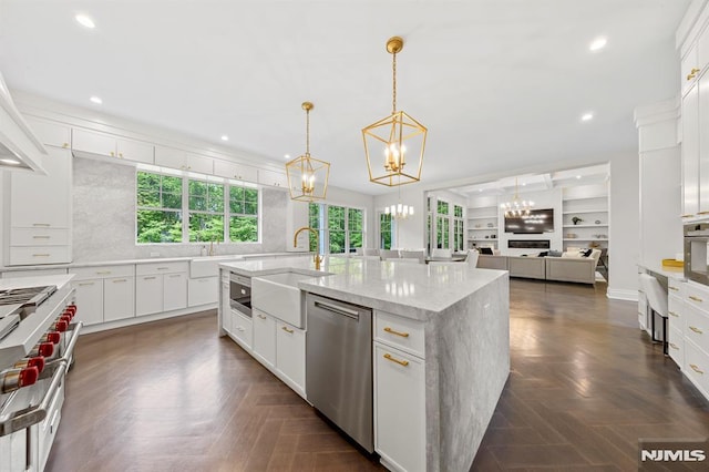 kitchen with appliances with stainless steel finishes, dark parquet floors, sink, pendant lighting, and white cabinetry