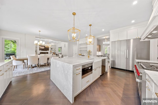 kitchen with white cabinets, pendant lighting, a center island, and stainless steel appliances