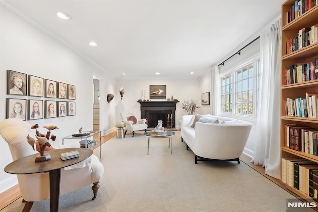 living area with carpet flooring and ornamental molding