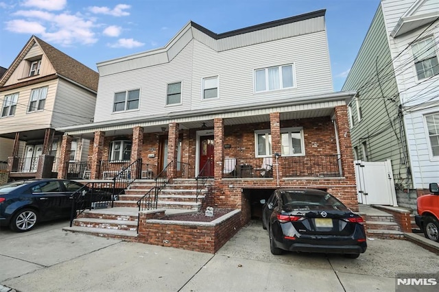 multi unit property featuring a garage and covered porch