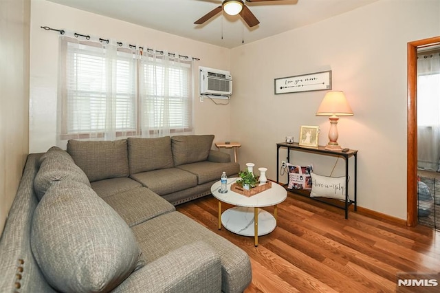 living room featuring ceiling fan, wood-type flooring, and an AC wall unit